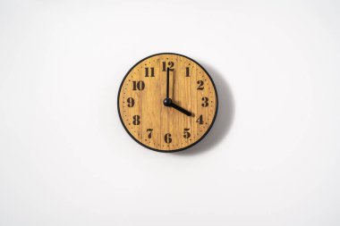 Beyaz zemin üzerinde beyaz kadranlı ahşap ofis duvar saati. Beyaz arkaplanda duvar saati, en üst görünüm.