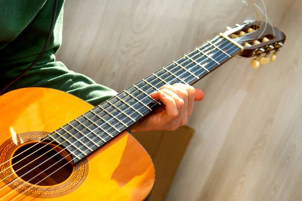 Gitar çalıyor. Gitar telleri ve parmaklar. Müzik aleti. İnsan ve gitar.