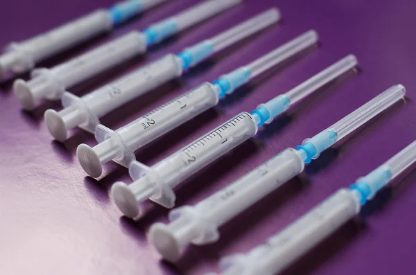 Syringes on purple background — Stock Photo, Image