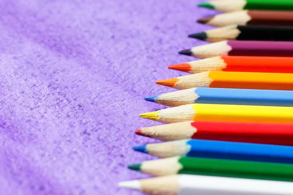 Lápis multicoloridos para desenho em fundo violeta — Fotografia de Stock