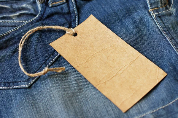 Etiqueta de etiqueta de papel en blanco en jeans —  Fotos de Stock