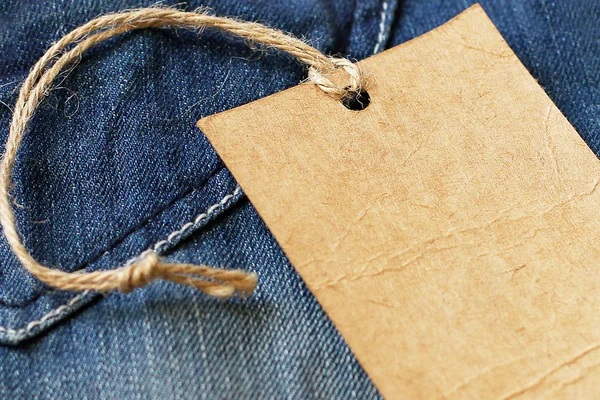 Blanco papier label label fragment op jeans — Stockfoto