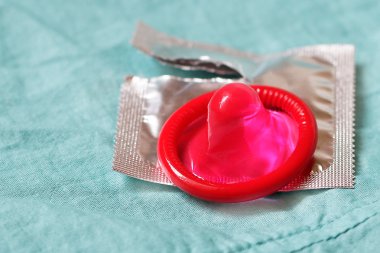 Mavi çarşaf üzerinde pembe prezervatif