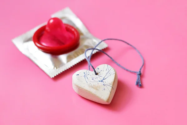 Heart and red condom — Stock Photo, Image