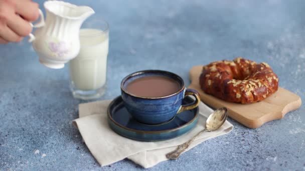牛乳瓶の女性の手はコーヒーカップに牛乳を注ぐ ミルクとパンと健康的な朝食コーヒー 4K解像度 — ストック動画