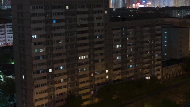 El lapso de tiempo de la ciudad nocturna. La casa está dormida, las luces parpadean en las ventanas, las luces se encienden y apagan — Vídeos de Stock