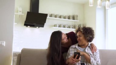 Mutlu kız arkadaşlar evdeyken akıllı telefona bakarlar.