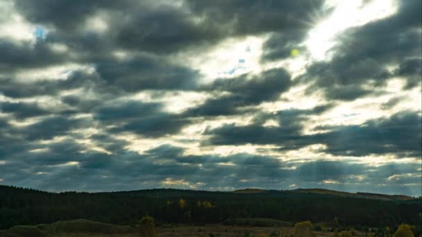 Time Lapse: un cielo dramático. Los rayos del sol rompen a través de las muchas nubes otoñales que barren la tierra — Vídeo de stock