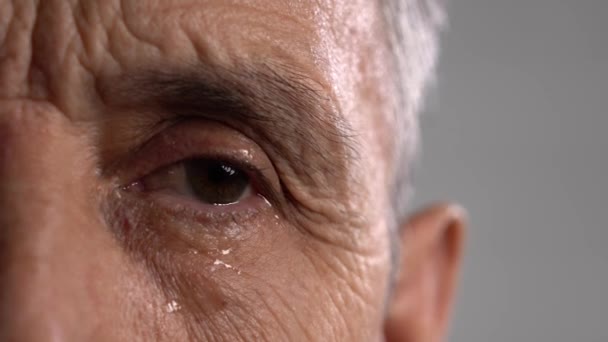 Lágrimas en la cara de un hombre arrugado. La mitad de los hombres mayores se enfrentan en primer plano — Vídeos de Stock