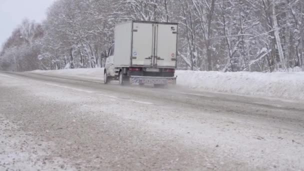 Ecaterimburgo, Rússia - janeiro de 2021. Moscas de neve soltas de baixo de rodas de caminhão na estrada — Vídeo de Stock