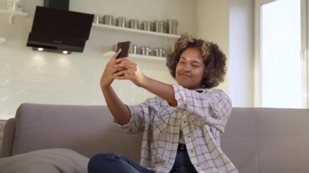 Una joven afroamericana feliz se toma selfies en su casa — Vídeos de Stock