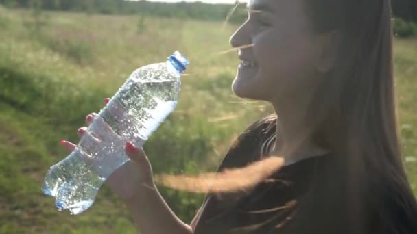 La ragazza apre una bottiglia di acqua minerale frizzante e bevande, godendo — Video Stock