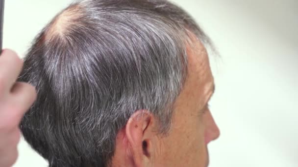 Seorang pria tua berambut abu-abu di sebuah barbershop — Stok Video
