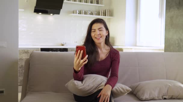 Heureuse jeune femme asiatique sourit tout en utilisant son smartphone — Video