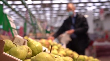 Süpermarkette taze meyve, yakın plan. Alışveriş yapan kişi yemek pişirmek için taze bir malzeme alır..