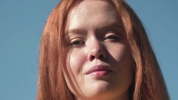 Retrato de una chica sonriente con el pelo rojo y pecas contra un prado soleado brillante. Belleza natural con pecas — Vídeo de stock