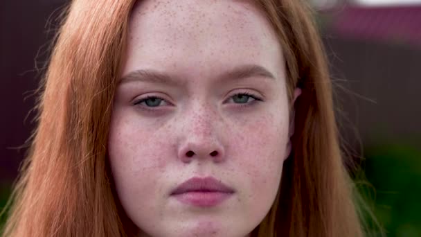 18-ti letá zrzavá dívka se smutně podívá do kamery a utírá si slzy. Detailní záběr — Stock video