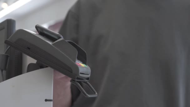 Pos terminal close-up at the time of payment. Wireless connection with a smartphone to pay for purchases at the checkout — Stock Video