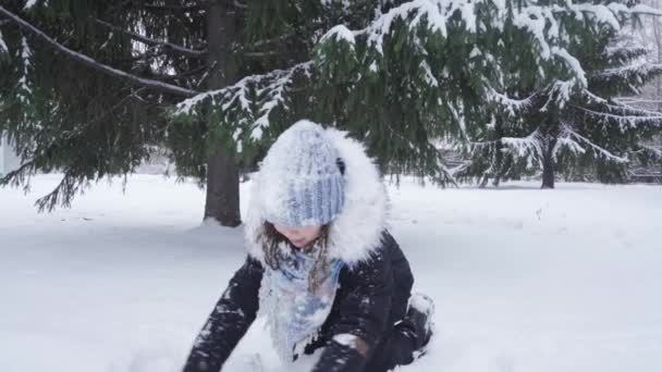 Adolescente jette de la neige fraîche tout en jouant dans le parc — Video