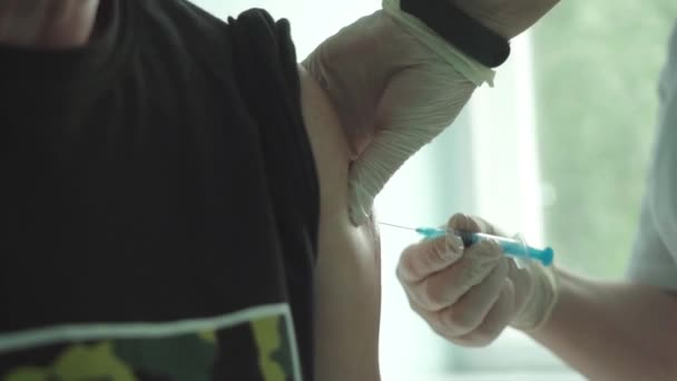 Μια γυναίκα γιατρός εμβολιάζει έναν ηλικιωμένο άνδρα κατά του ιού της στέψης.. — Αρχείο Βίντεο