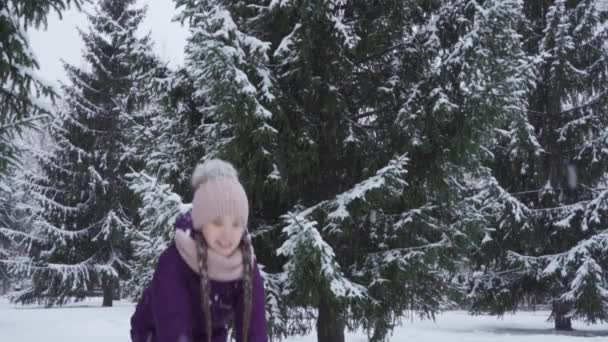 MOCIÓN LENTA: Una adolescente feliz lanza nieve fresca al aire — Vídeo de stock