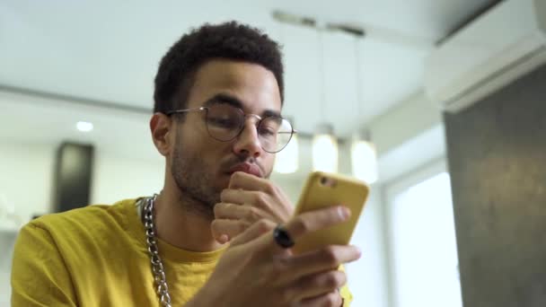 Un joven africano usa un smartphone. — Vídeo de stock