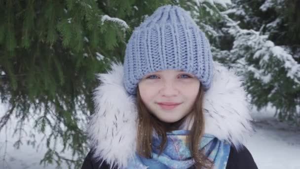Kar parkında mutlu, mavi gözlü genç bir kızın portresi. — Stok video