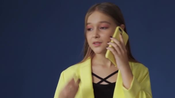 Dospívající dívka v chytrém oblečení je chatování na telefonu se svou přítelkyní — Stock video
