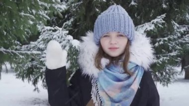 Kar parkında mutlu, mavi gözlü genç bir kızın portresi.