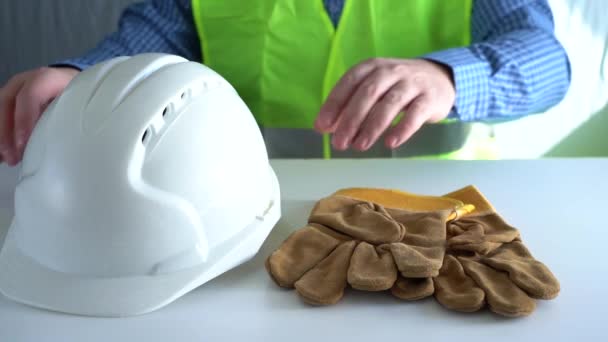 İşçilerin elleri masadan koruyucu bir kask ve eldiven alır. Kişisel koruyucu ekipman almak — Stok video