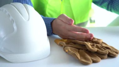 İşçilerin elleri masadan koruyucu bir kask ve eldiven alır. Kişisel koruyucu ekipman almak