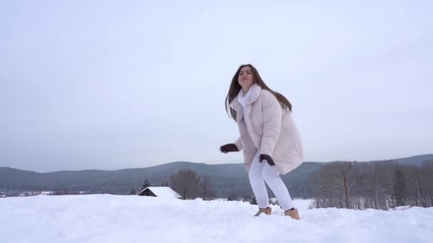 En vacker ung kvinna njuter av livet mot bakgrund av en vinterskog. — Stockvideo