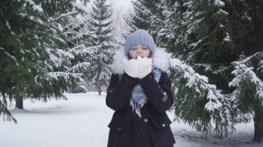 Kar parkında mutlu, mavi gözlü genç bir kızın portresi.