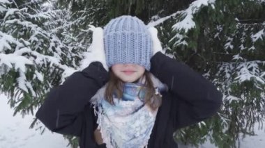 Kar parkında mutlu, mavi gözlü genç bir kızın portresi.