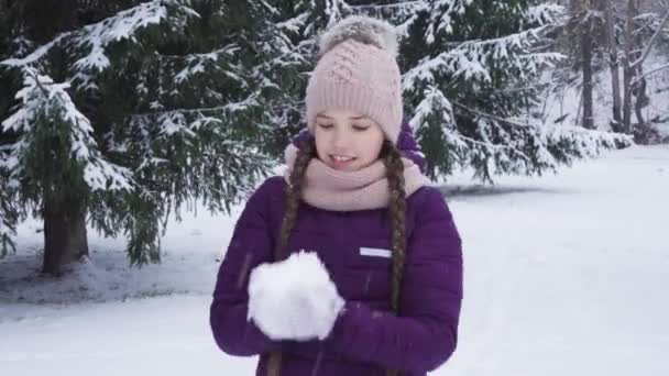 Happy teenage girl tossing up fluffy snow — Stock Video