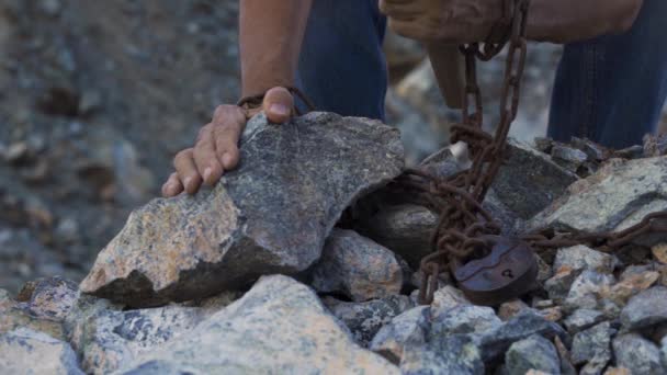 Slave labor in a quarry. The convicts hands are holding a hammer — Stock Video