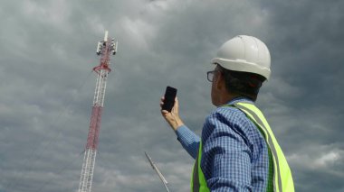 Telekomünikasyon mühendisi bir telekomünikasyon kulesinden gelen sinyali kontrol ediyor..
