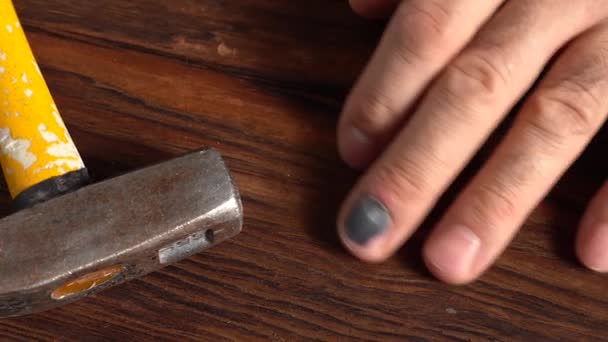 Ein geschwärzter Fingernagel am Finger eines Mannes mit einem Bauhammer — Stockvideo