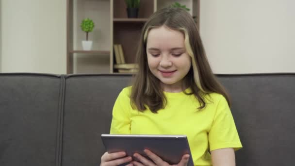Щаслива дівчина дивиться відео на своєму планшетному комп'ютері — стокове відео