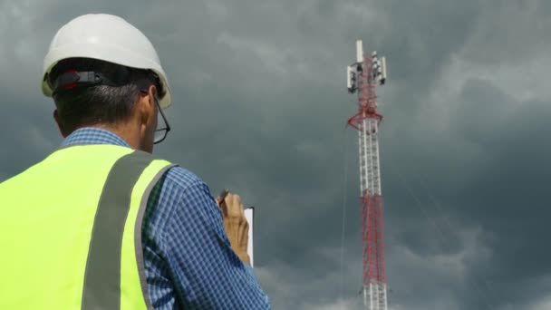 Ingeniero de telecomunicaciones comprobando la señal desde una torre de telecomunicaciones — Vídeo de stock