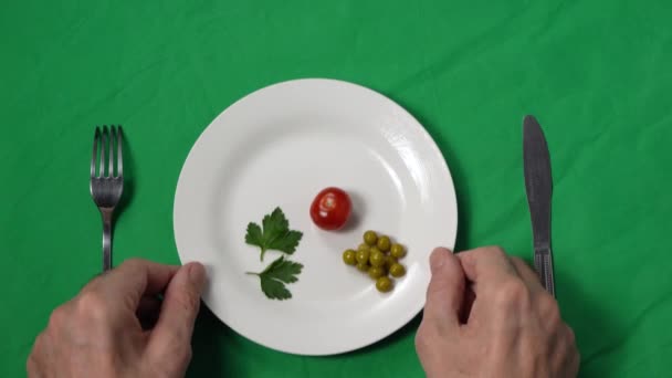Las manos de un hombre se acercan al plato de comida pobre. Control de porciones. El concepto de pérdida de peso y alimentación saludable. Los ingredientes naturales. Verduras y alimentación saludable. Vista superior — Vídeo de stock
