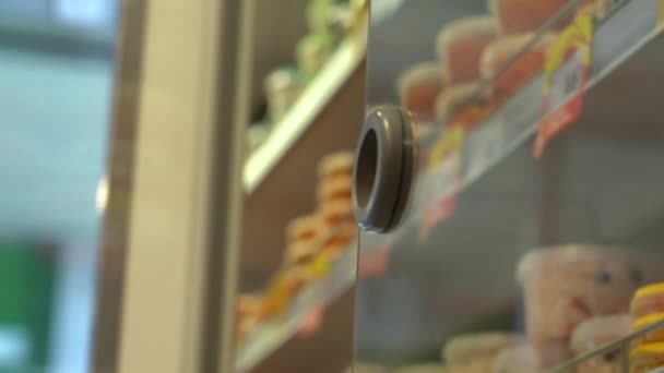 Müşteri raftan soğutulmuş ürünü almak için mağazadaki buzdolabını açar. Alışveriş yapan kişi marketin buzdolabından yiyecek seçer. — Stok video