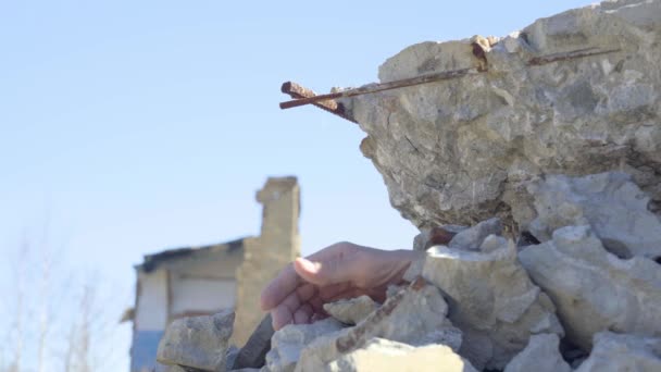 A weakened mans hand reaches up from under the rubble. Barely alive man pinned by the rubble of the wall asks for help — ストック動画