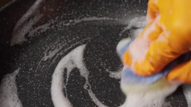 Pan 'ı sünger ve deterjanla yıka. Süngerli Eldiven Kirli Tavayı Yıkar.
