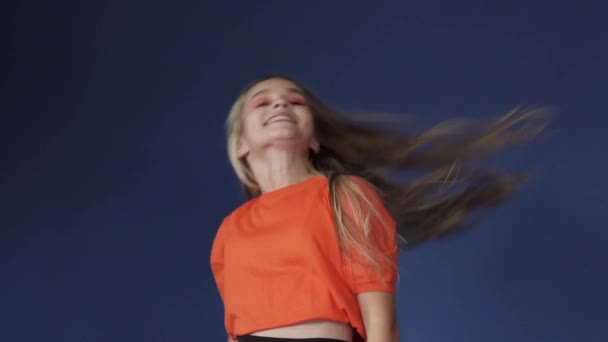 En ung flicka viftar med långt hår. — Stockvideo