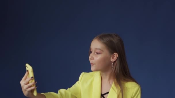 Tinédzser lány pimasz ruhában szelfit csinál a telefonján. — Stock videók
