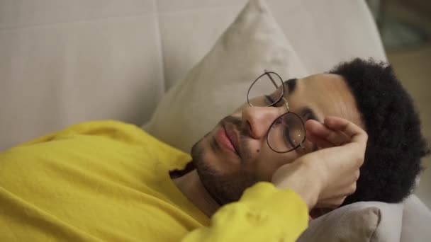 Portrait of a young man lying on a couch — Stock Video