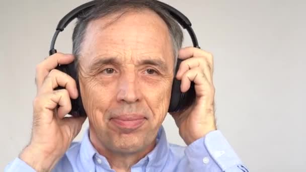 Boldog idősebb férfi zenét hallgat — Stock videók