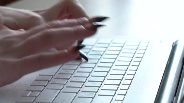 Vrouwelijke handen van een vrouw typen op een laptop toetsenbord terwijl zitten aan haar bureau — Stockvideo
