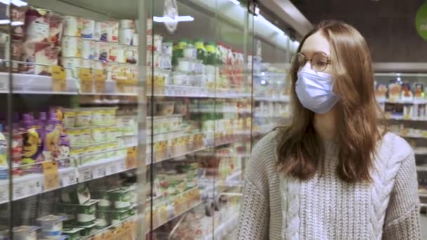 Joven comprador camina por los pasillos de un supermercado — Vídeos de Stock